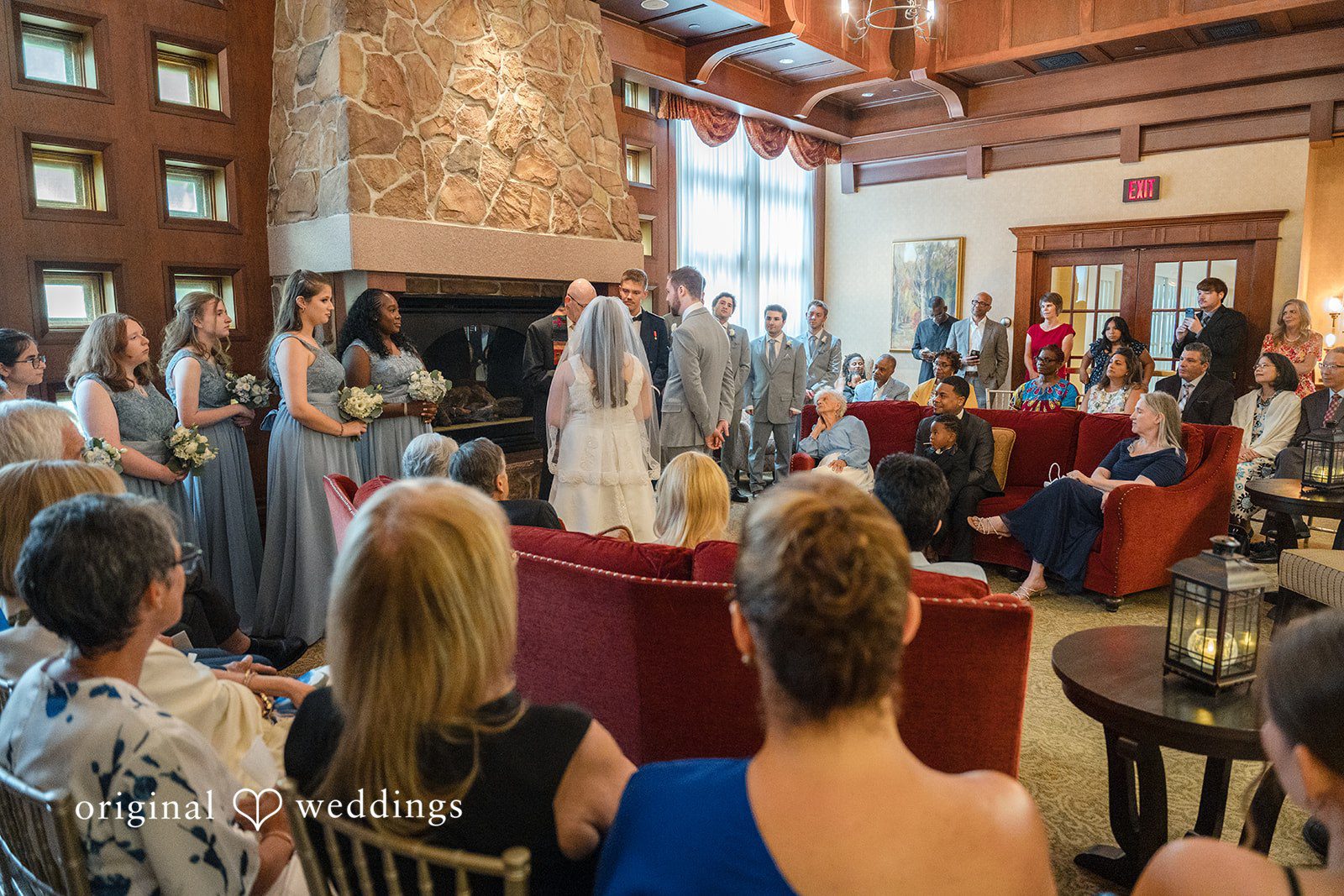 Ava + Zach A view from behind the seated guests watching a wedding ceremony take place.