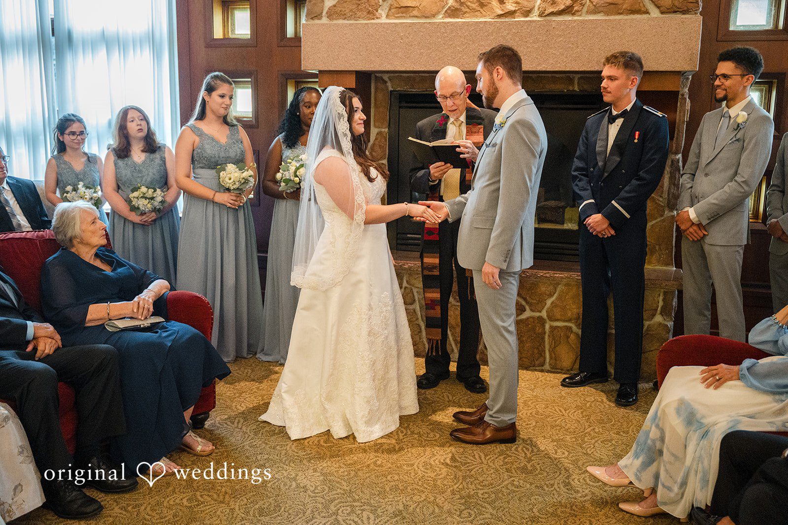 Ava + Zach A wedding ceremony in progress with the wedding party standing on both sides.