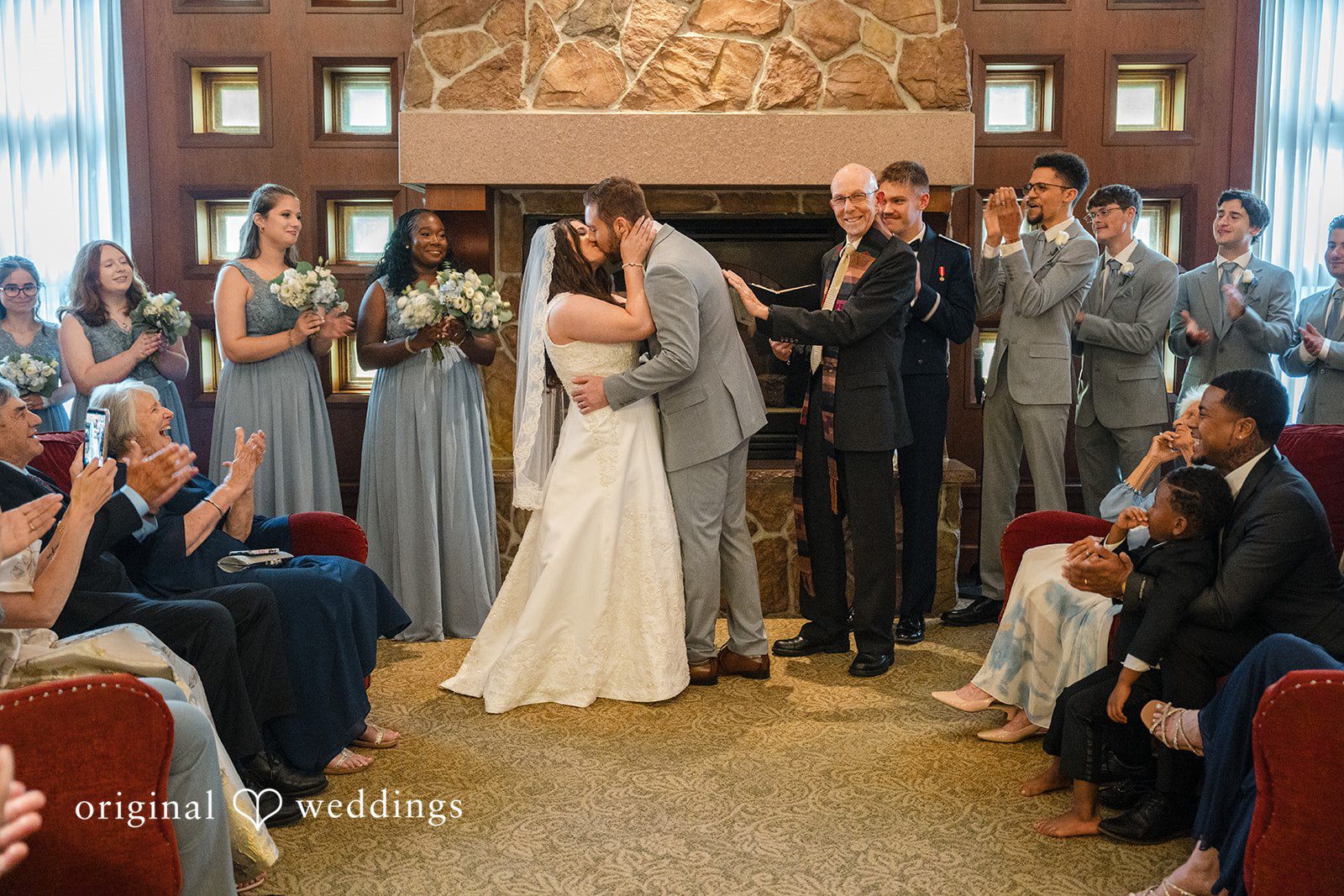 Ava + Zach A bride and groom sharing a kiss at the altar during their ceremony.
