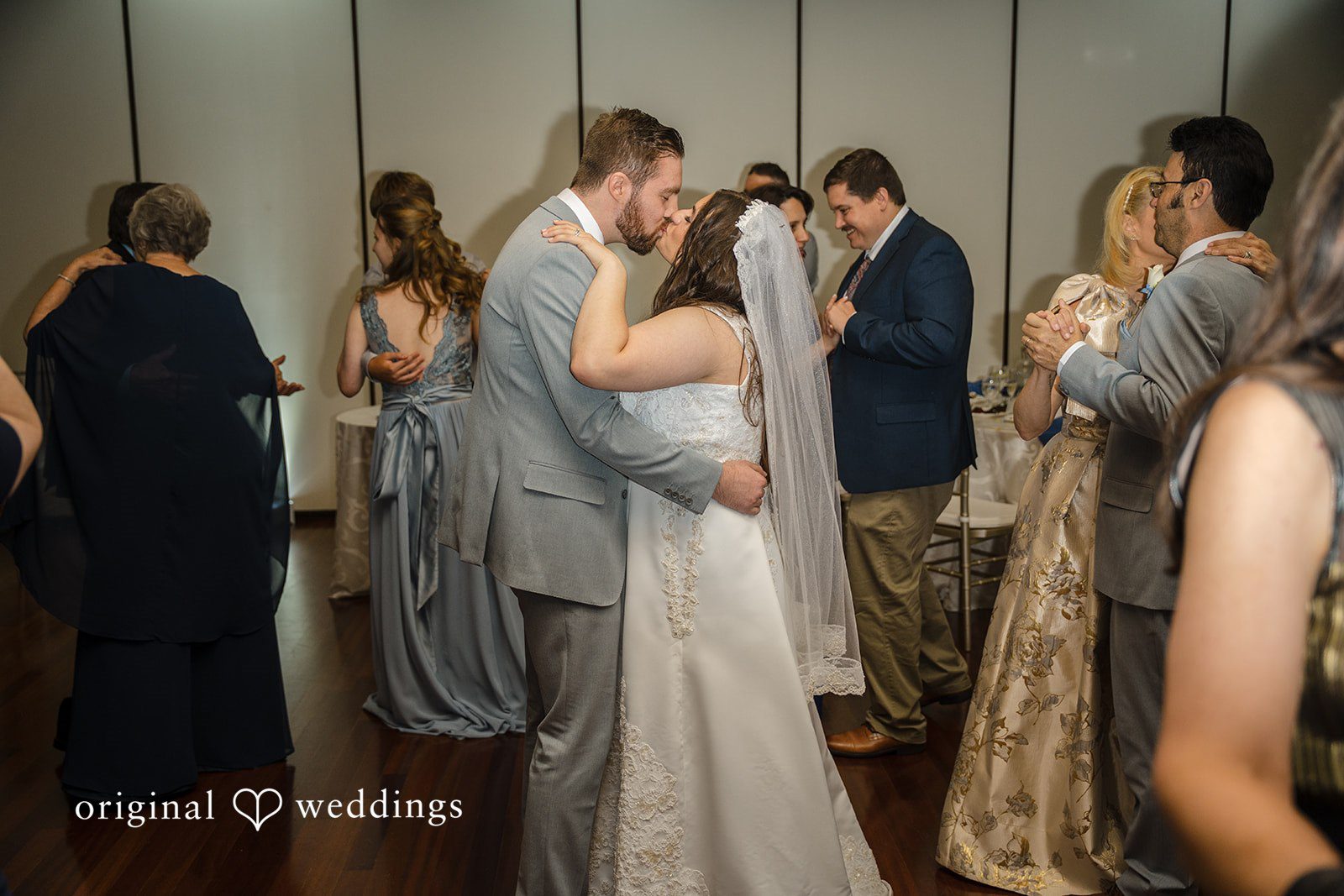 Ava + Zach A bride and groom sharing a slow dance together surrounded by wedding guests.