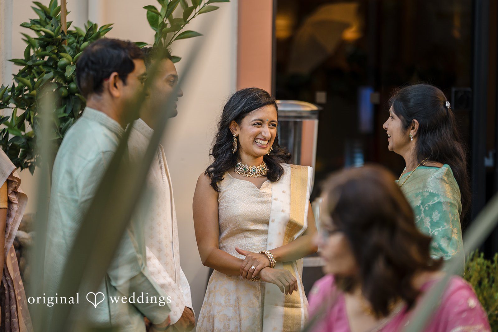 Kathir + Nandita A bride and groom interacting with family members at a wedding venue.