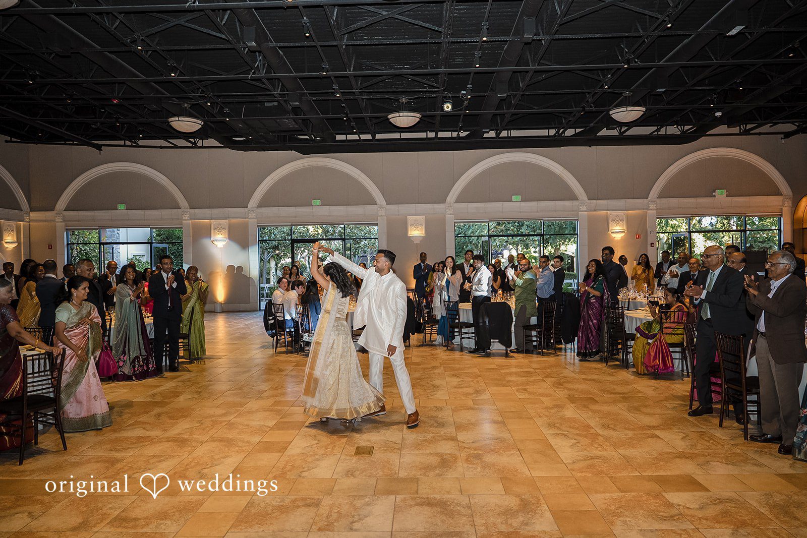 Kathir + Nandita A wide view of wedding guests gathered around a dance floor during a celebration.