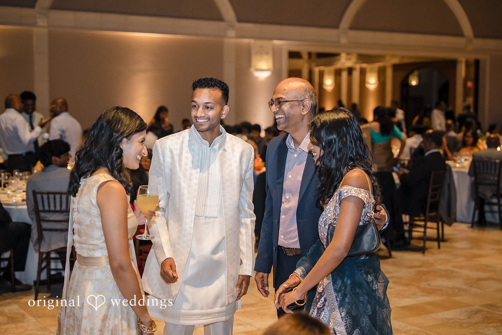 Kathir + Nandita A group of wedding guests interacting during a lively reception party.