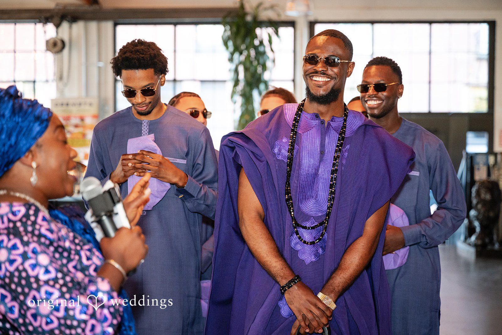 A group of wedding guests laughing and clapping in celebration.