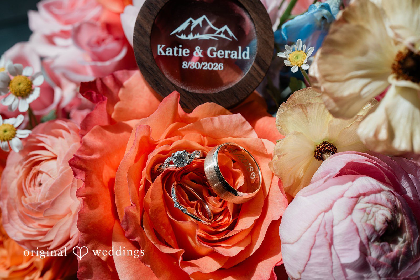 Katie + Gerald A close-up view of bright orange and pink floral wedding arrangements.