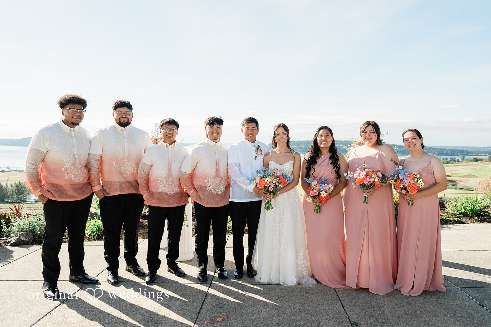 Katie + Gerald A large wedding party standing together in a line along a scenic overlook.