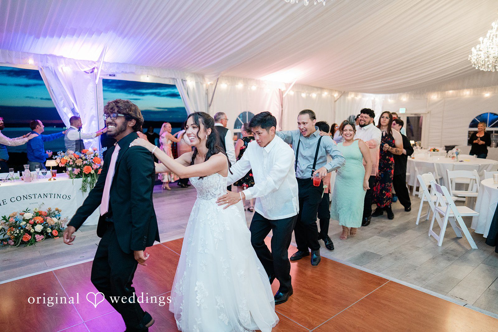 Katie + Gerald A lively wedding reception with guests dancing under lights.