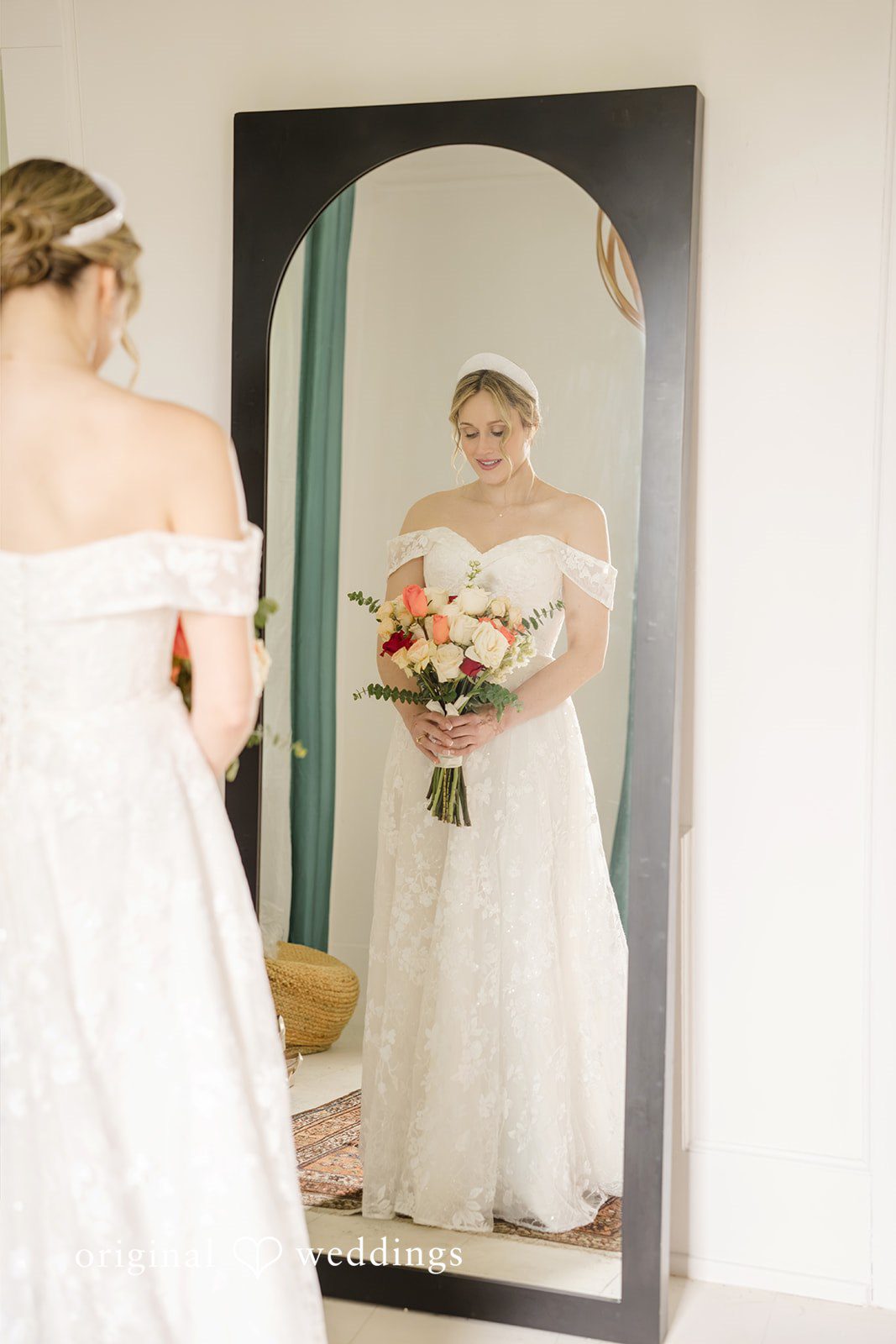 Julie + Joshua A bride in a white wedding gown standing in front of a full-length mirror.