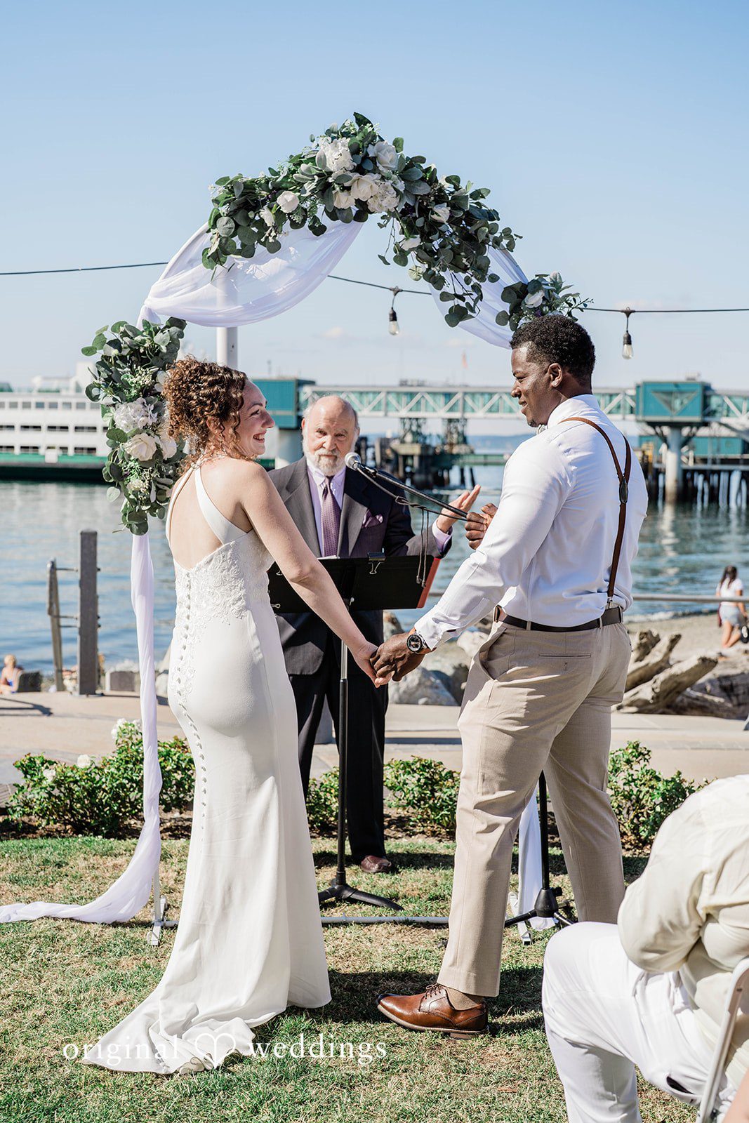 Naomi + Darrell Bride and groom holding hands during their wedding ceremony.