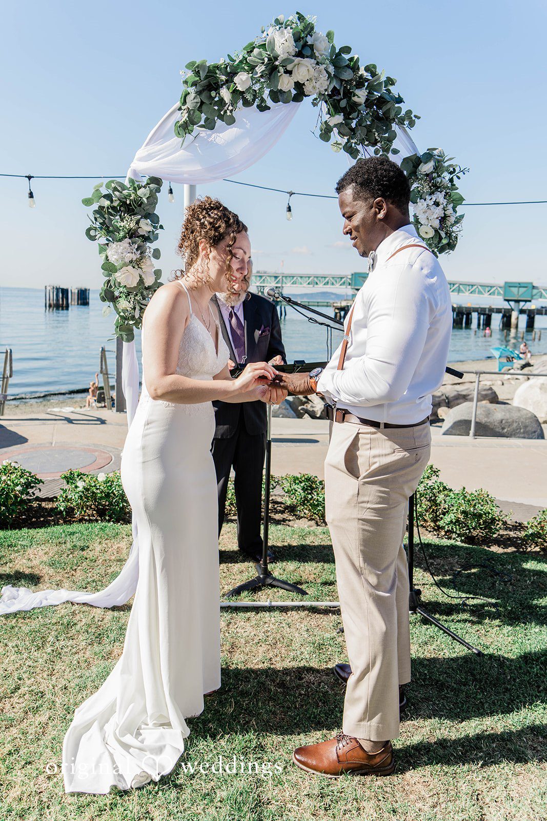 Naomi + Darrell Bride slipping a wedding ring onto the groom's finger.