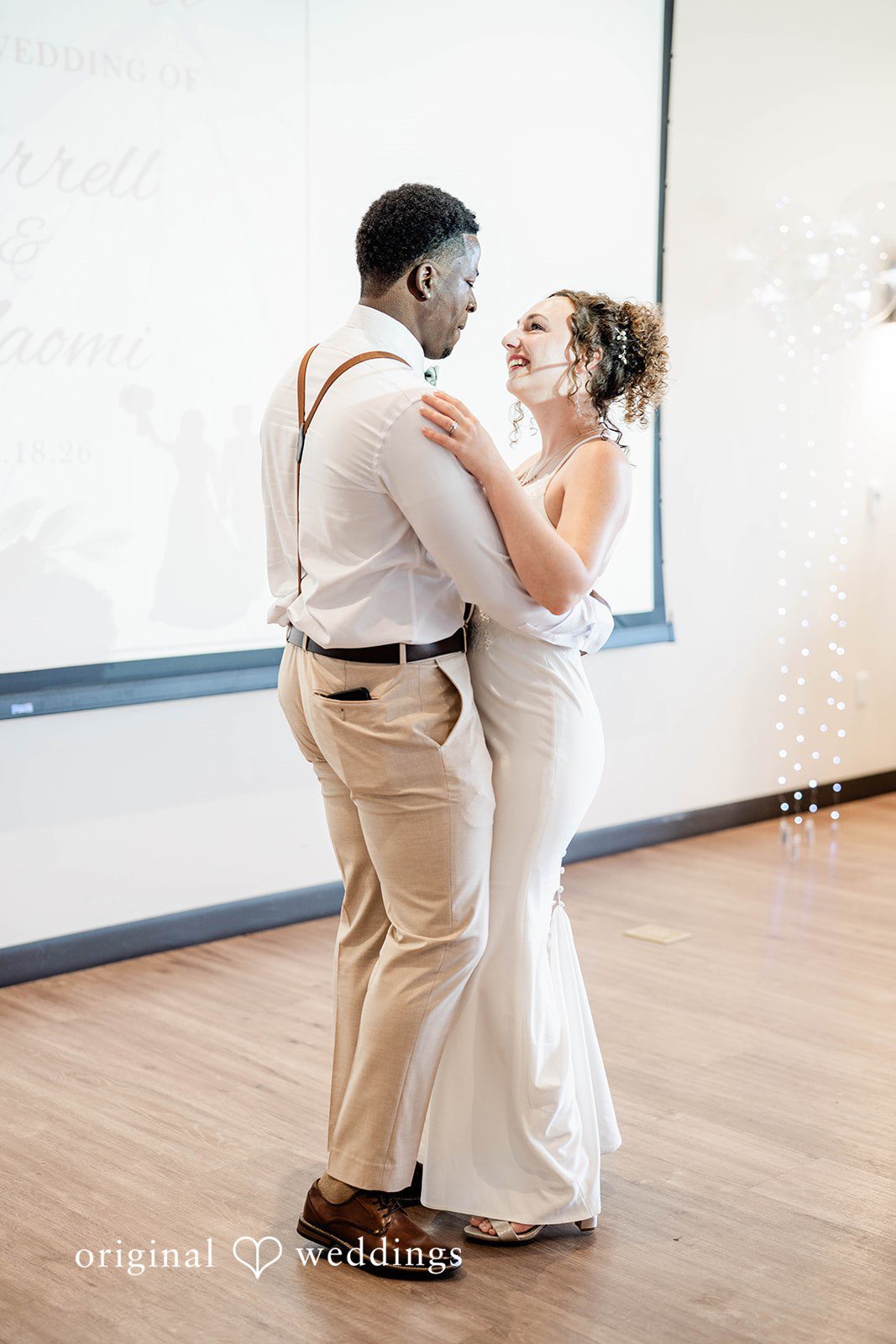 Naomi + Darrell Bride and groom dancing together on a wooden dance floor.