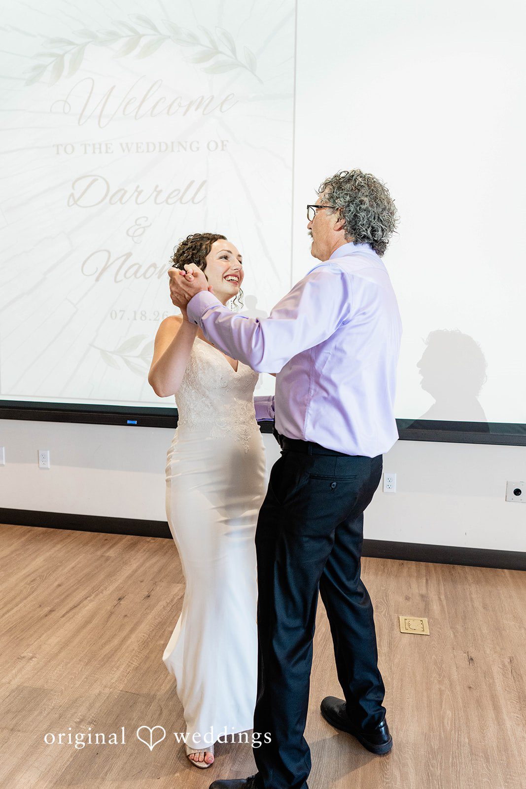 Naomi + Darrell Bride dancing with a wedding guest on a wooden dance floor.
