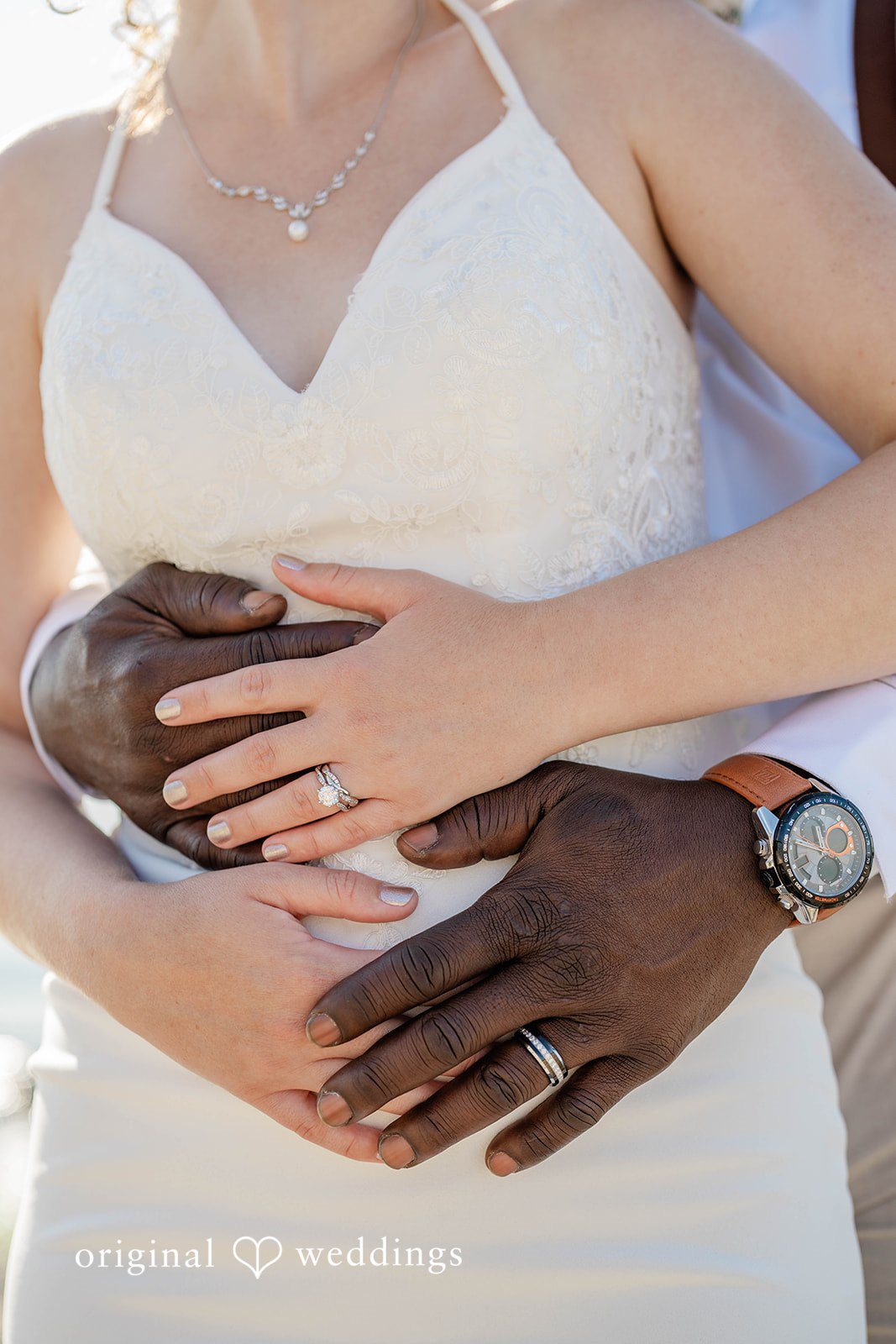 Naomi + Darrell Close-up of the groom's and bride's hand showing rings.
