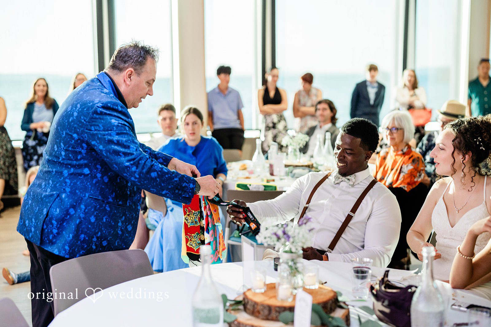 Naomi + Darrell Wedding guests interacting and raising drinks during a reception toast.