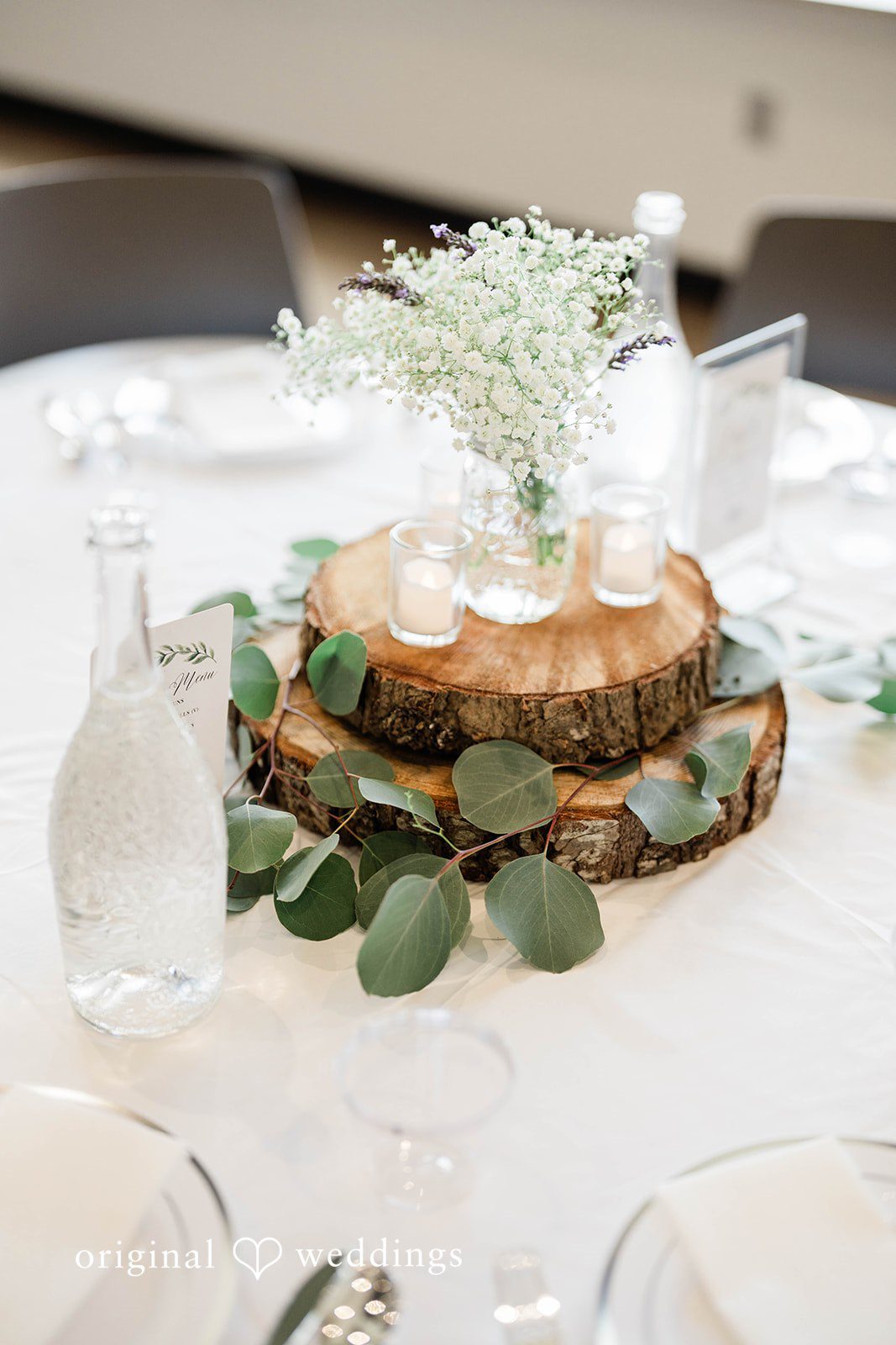 Naomi + Darrell Layered wedding cake adorned with white frosting and green leaves.