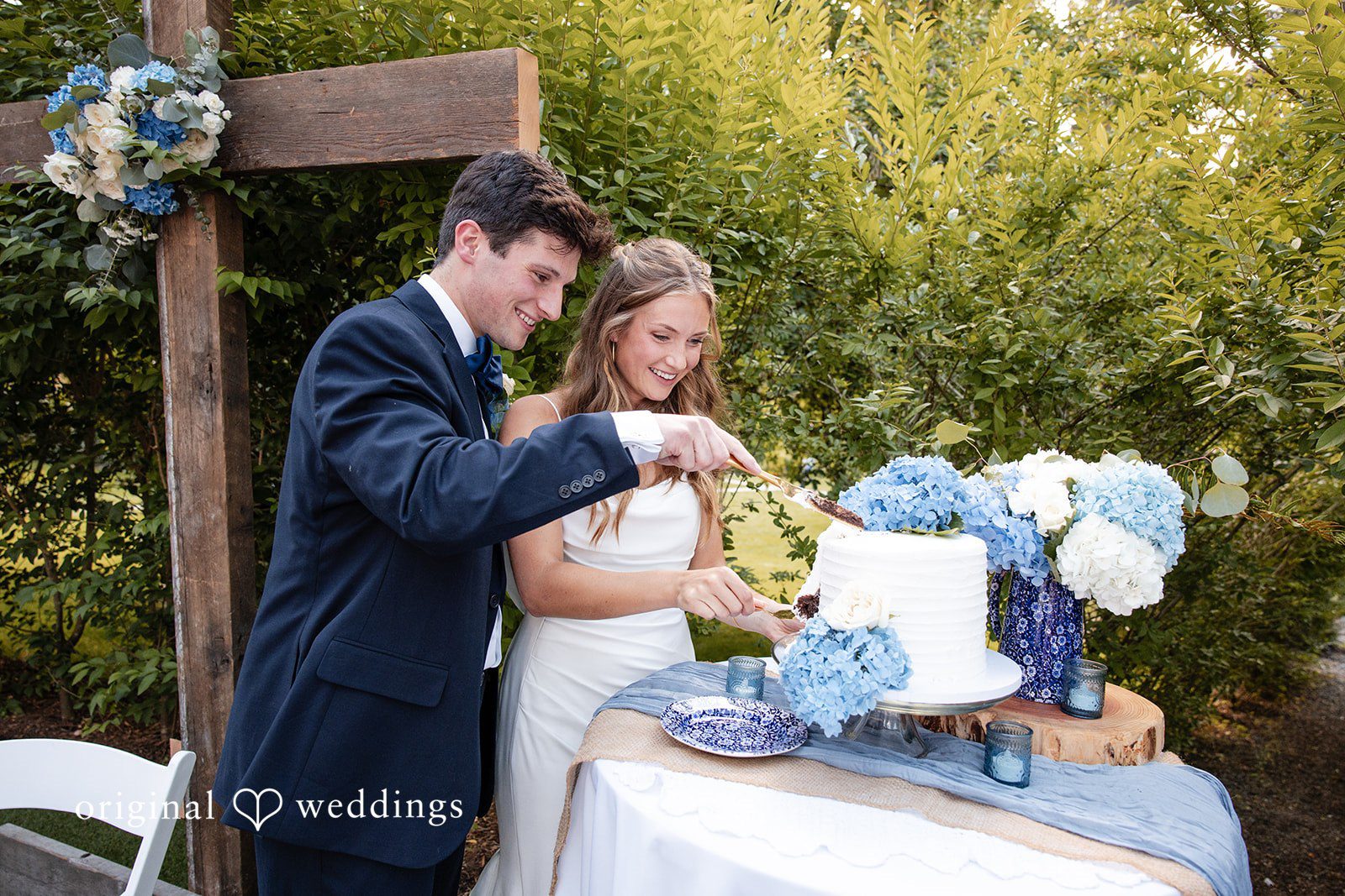 Alissa + Duncan A bride and groom cutting their wedding cake together at the reception.