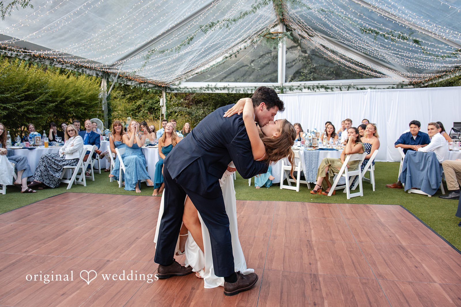 Alissa + Duncan A groom dipping his bride during a dance in front of seated wedding guests.