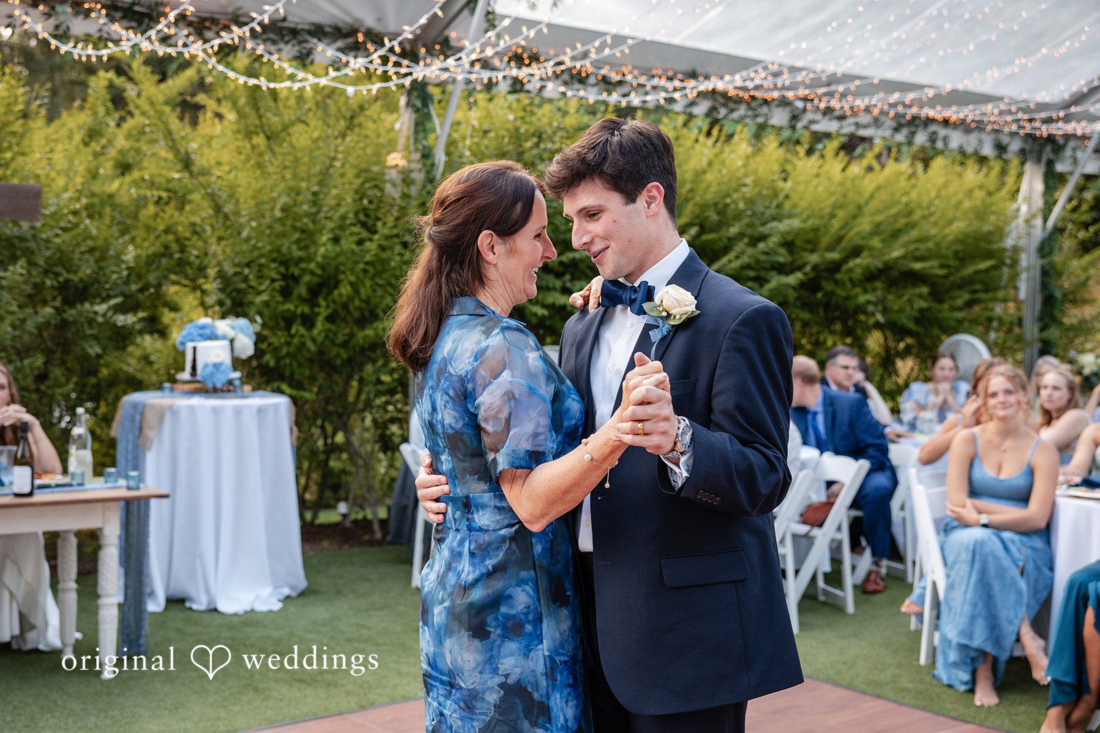 Alissa + Duncan A women in a blue dress dancing with a groom in a dark suit at a reception.