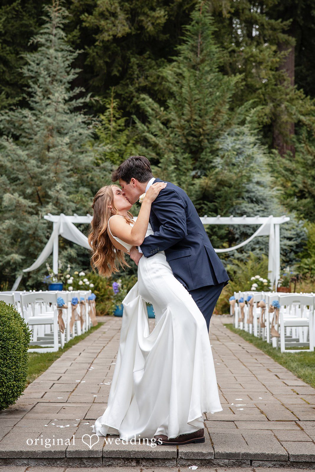 Alissa + Duncan A groom dipping his bride for a kiss on a brick walkway.