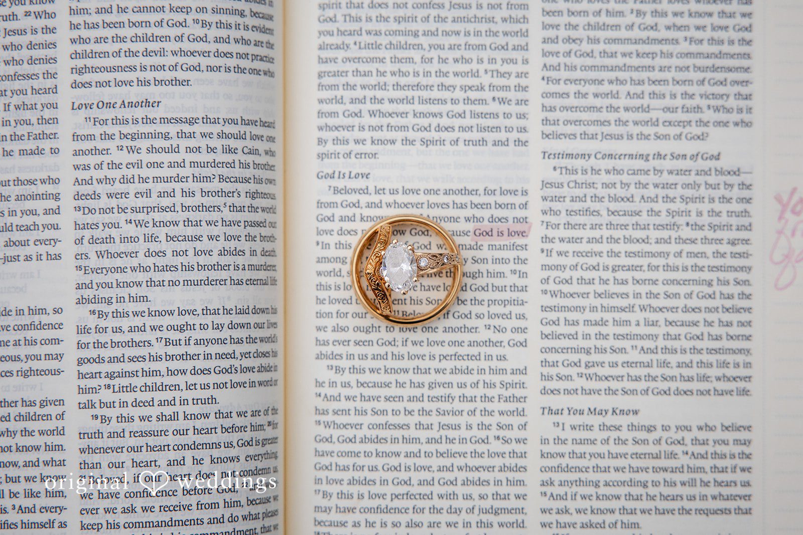 Alissa + Duncan An open Bible with a gold wedding ring resting on the text of a page.