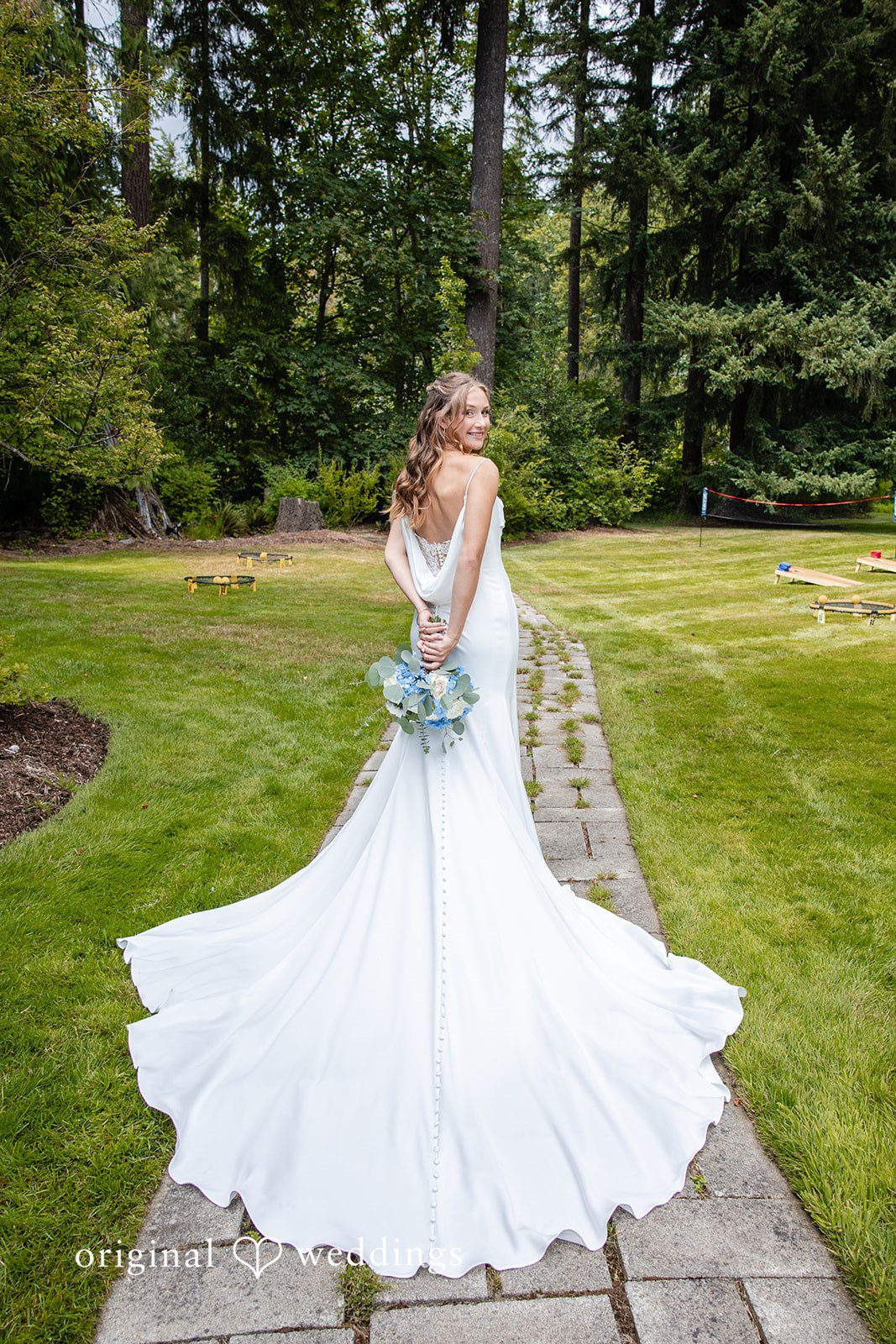 Alissa + Duncan A bride in a white wedding gown walking across a green lawn.
