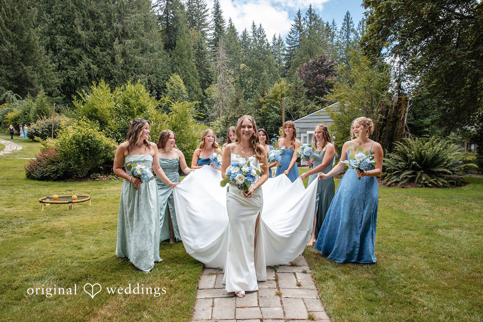 Alissa + Duncan A bridal party walking together down a path in light blue dresses.
