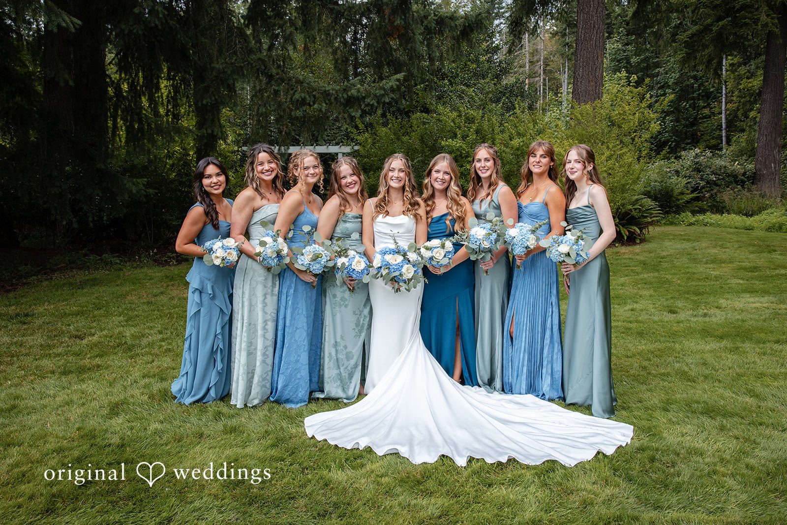 Alissa + Duncan A bride standing with her bridesmaids who are wearing coordinated blue gowns.