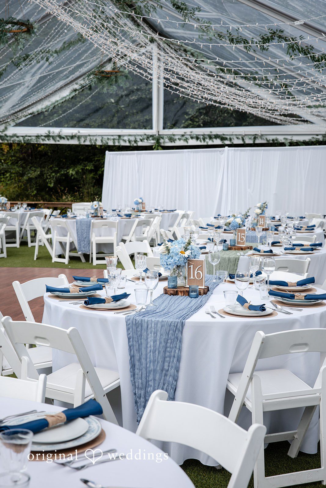 Alissa + Duncan A wedding reception table decorated with white linens and light blue napkins.