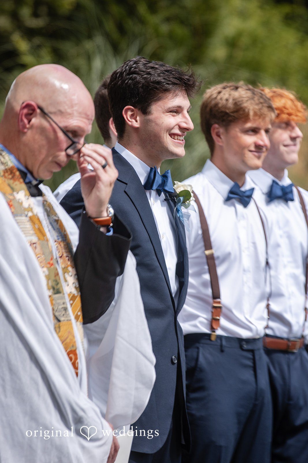 Alissa + Duncan A close-up of the groom and groomsmen smiling during a ceremony.