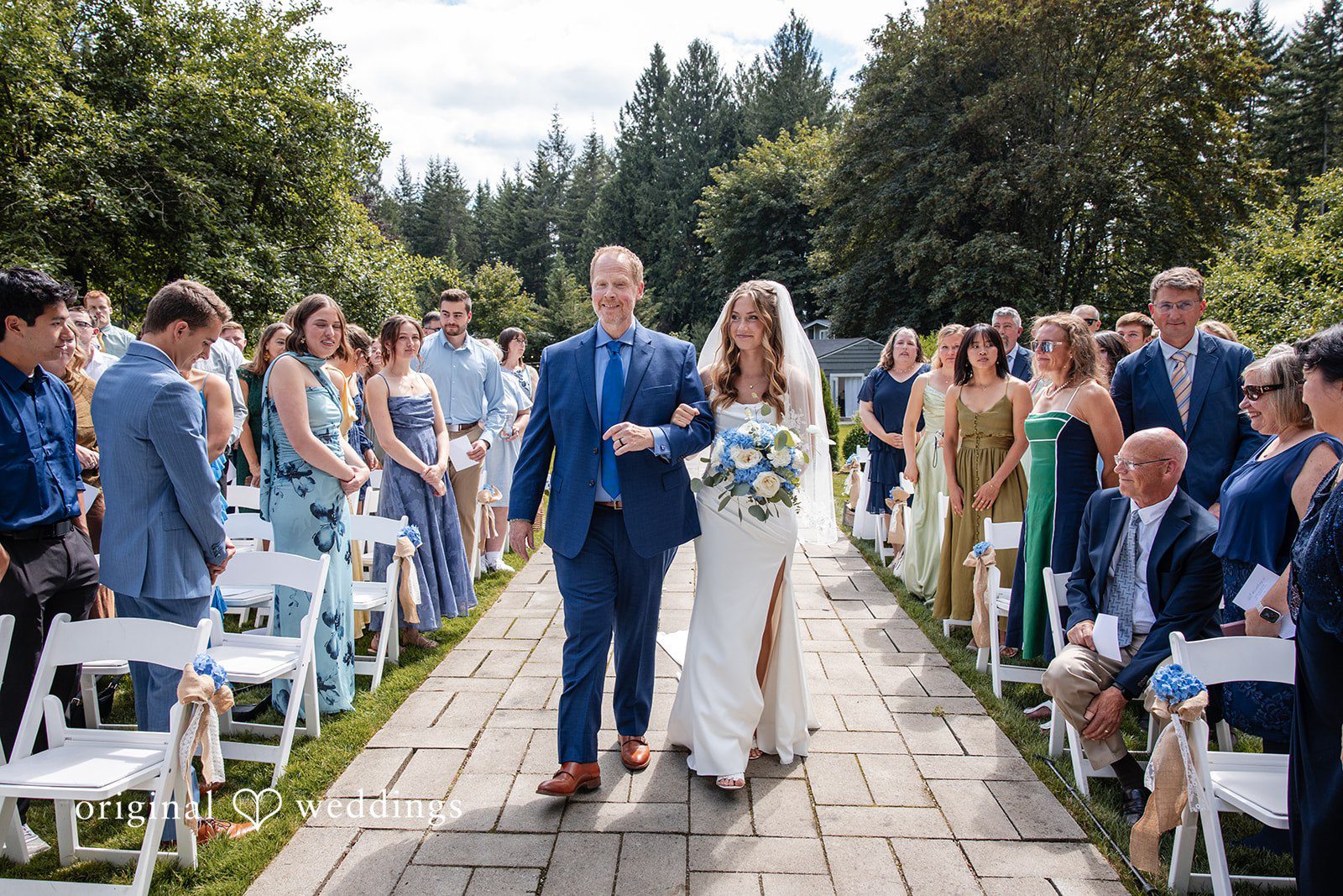 Alissa + Duncan A man and bride walking down the aisle while guests applaud.