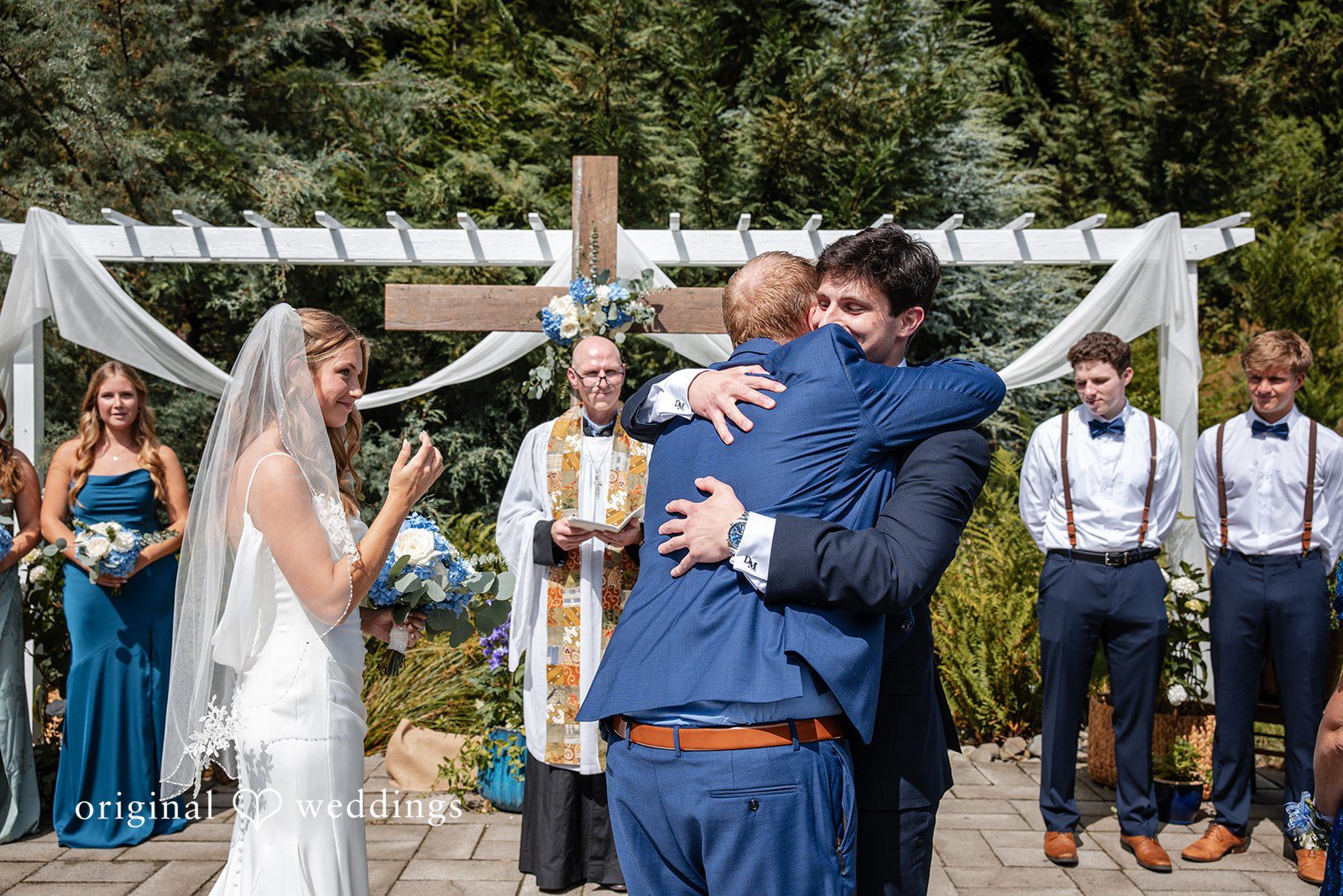 Alissa + Duncan A groom lifting and hugging a man at the altar before the ceremony.