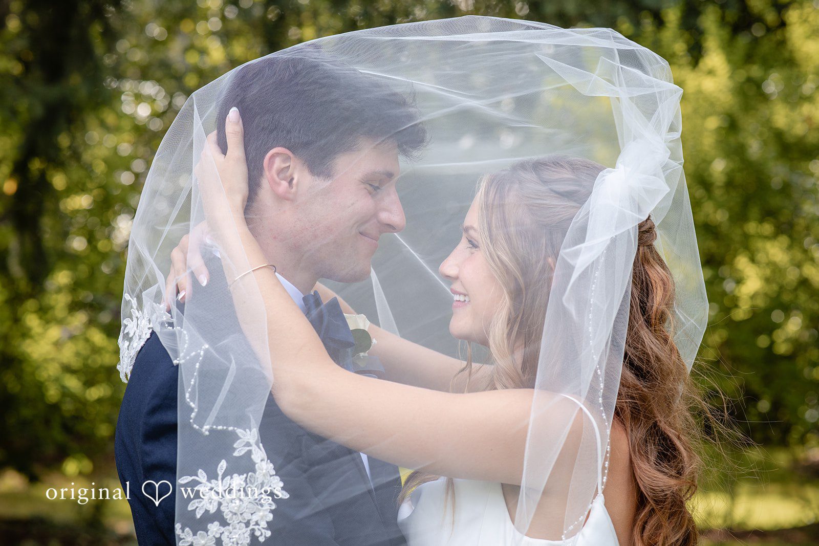 Alissa + Duncan A bride and groom sharing a moment completely wrapped underneath her sheer wedding veil.