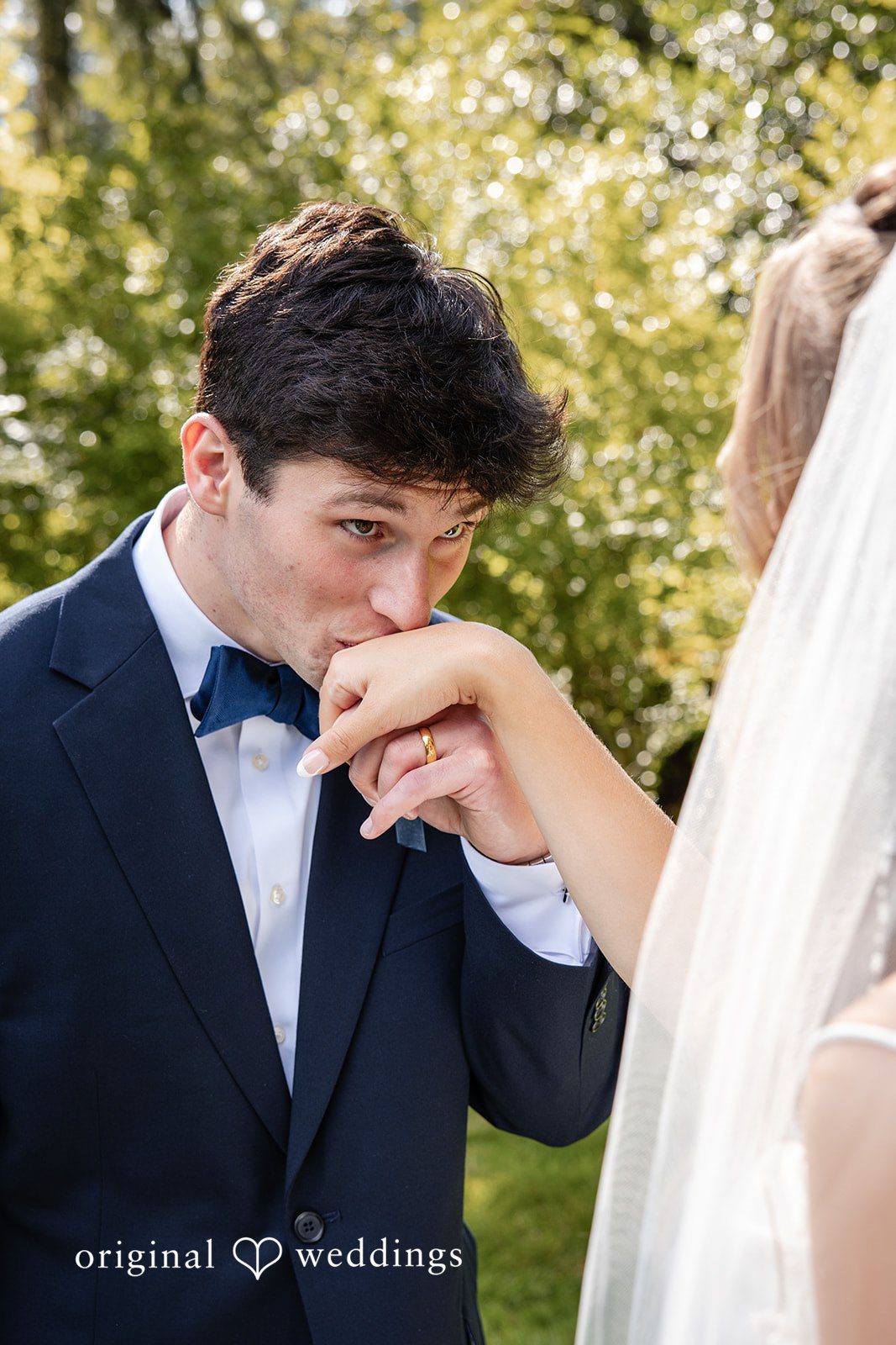 Alissa + Duncan A groom kissing the hand of his bride in a tender moment.
