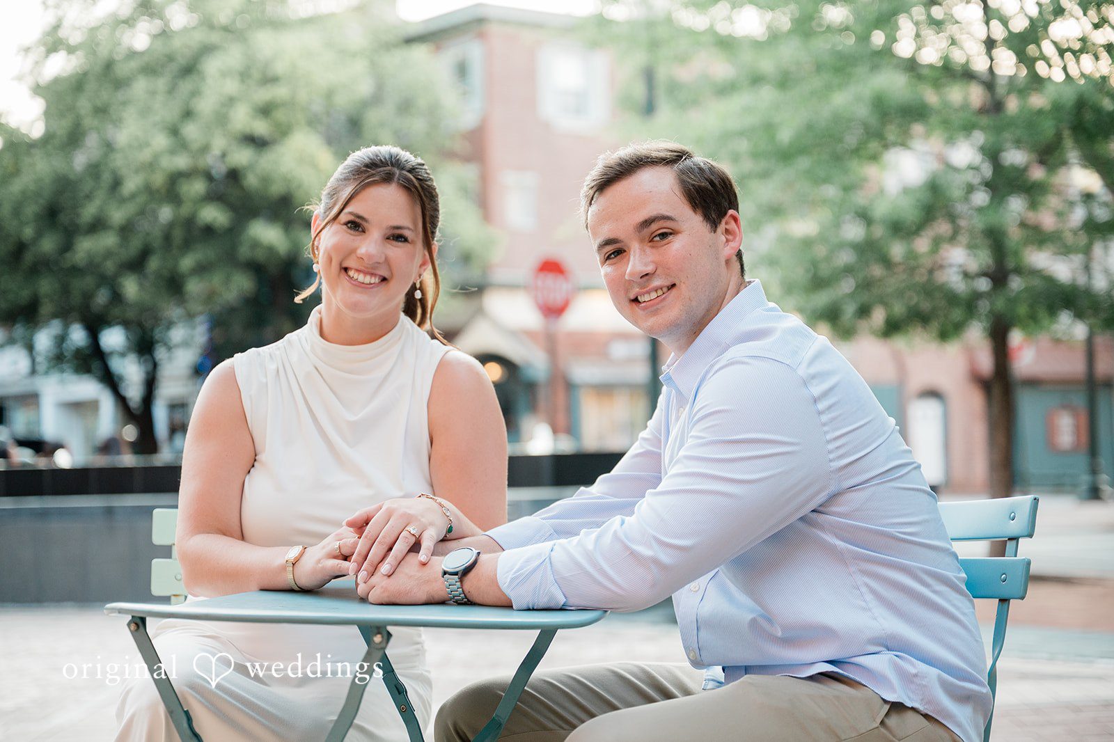A couple holding hands while sitting at a table together.
