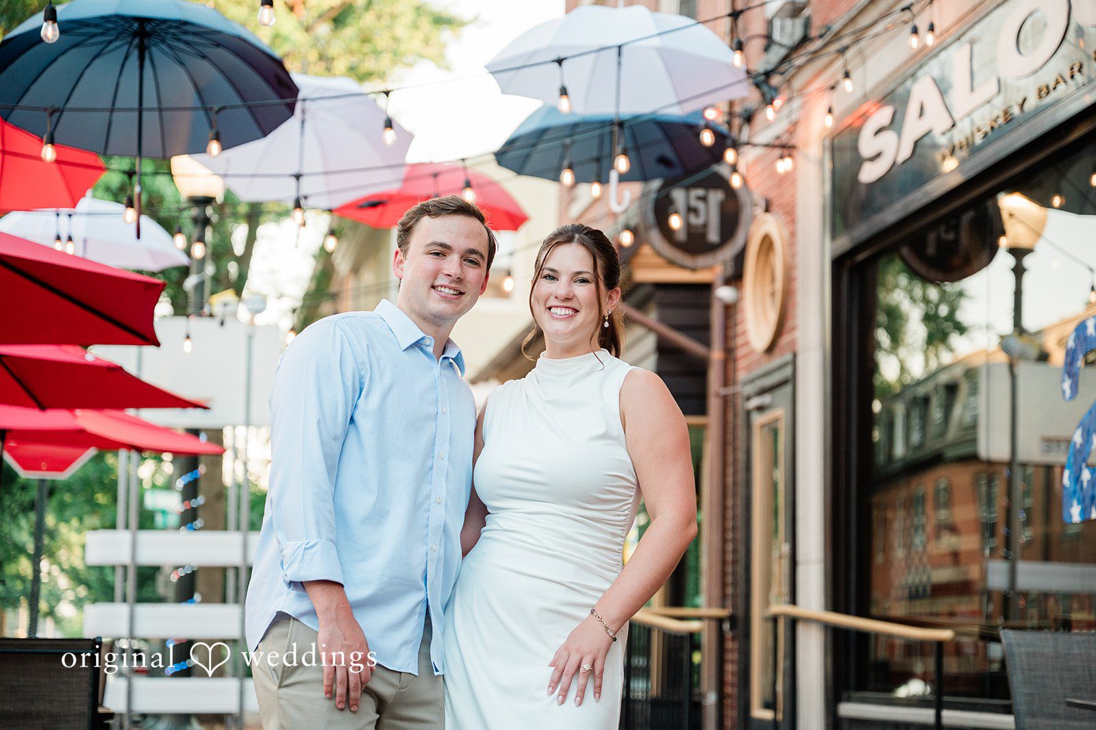 A couple standing together near a colorful storefront on a city street.