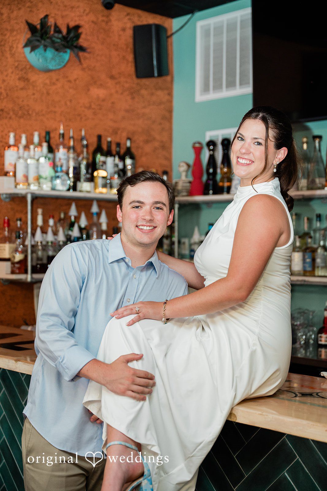 A couple sitting together at a restaurant counter, smiling warmly.