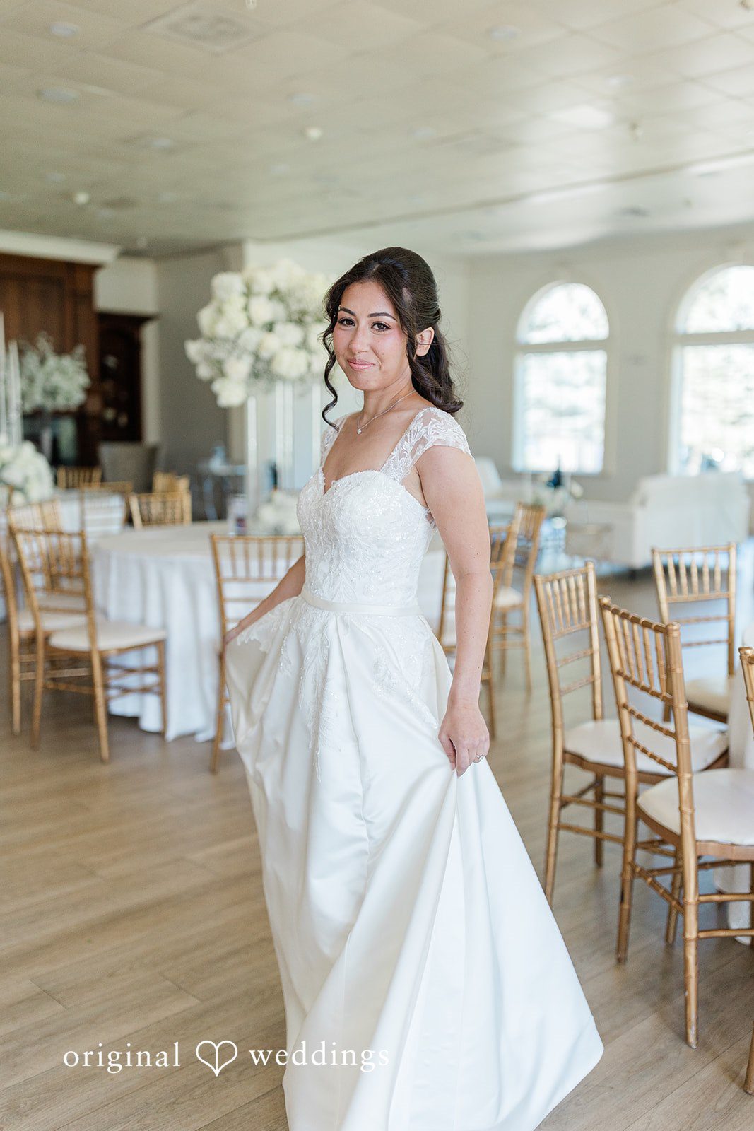 Julia + Camden A bride walking through an open room wearing a flowing white wedding dress.