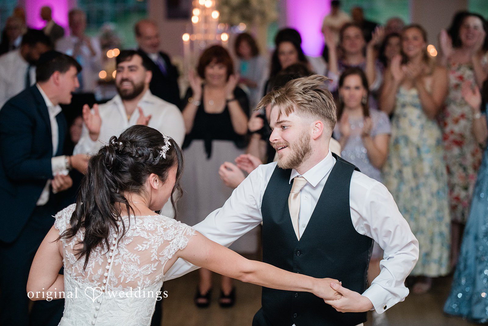 Julia + Camden Guests dance and celebrate together on a crowded reception dance floor.