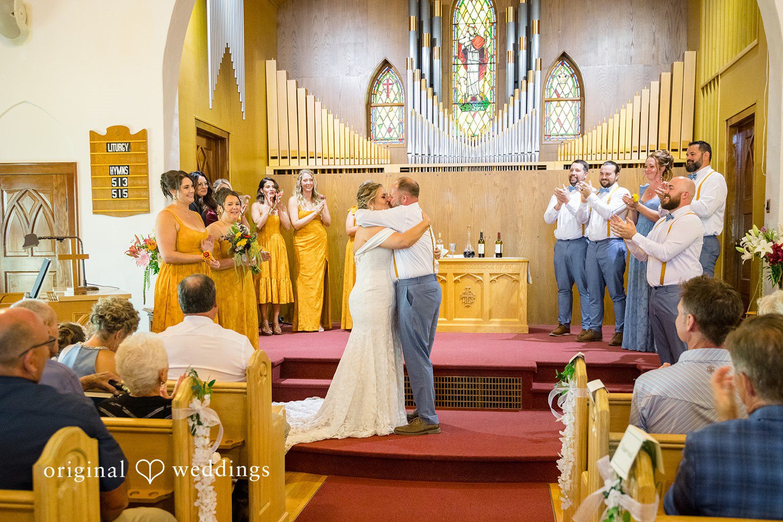 A wide shot of a wedding ceremony inside a traditional church with wooden architecture.