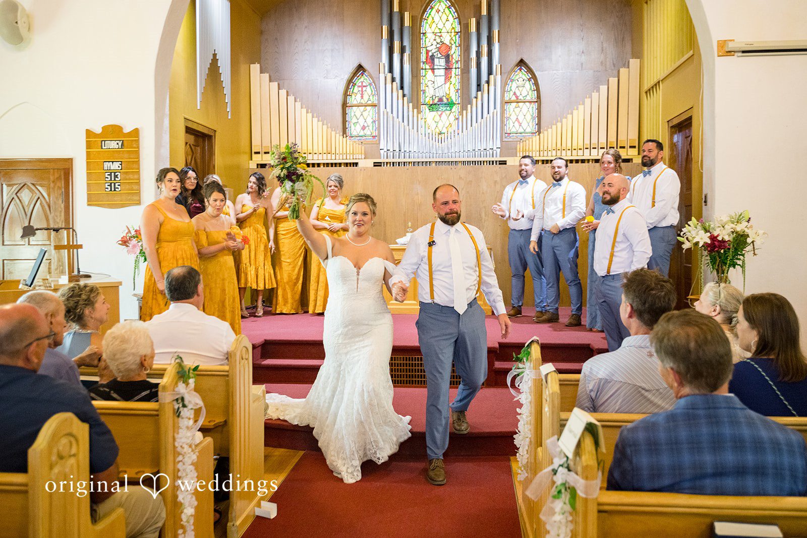 A bride and groom walking down the church aisle together after being married.