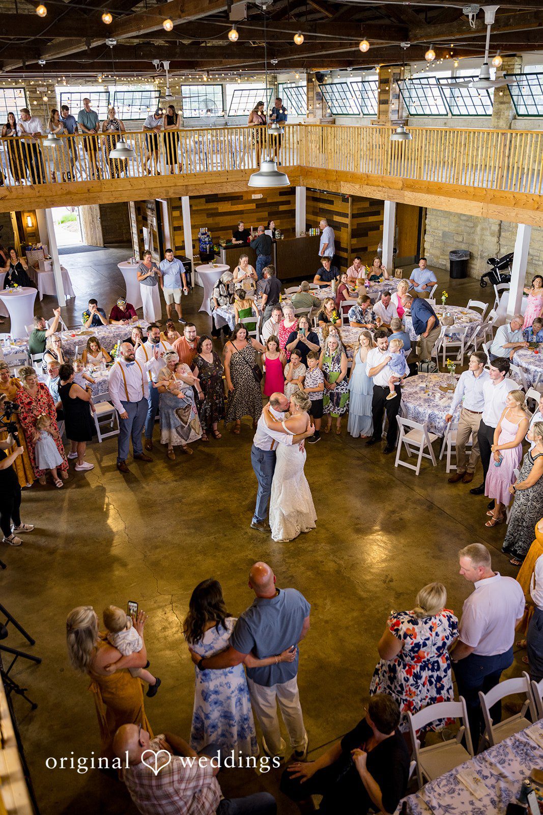 A high-angle view of a crowded dance floor filled with wedding guests during a lively reception party.