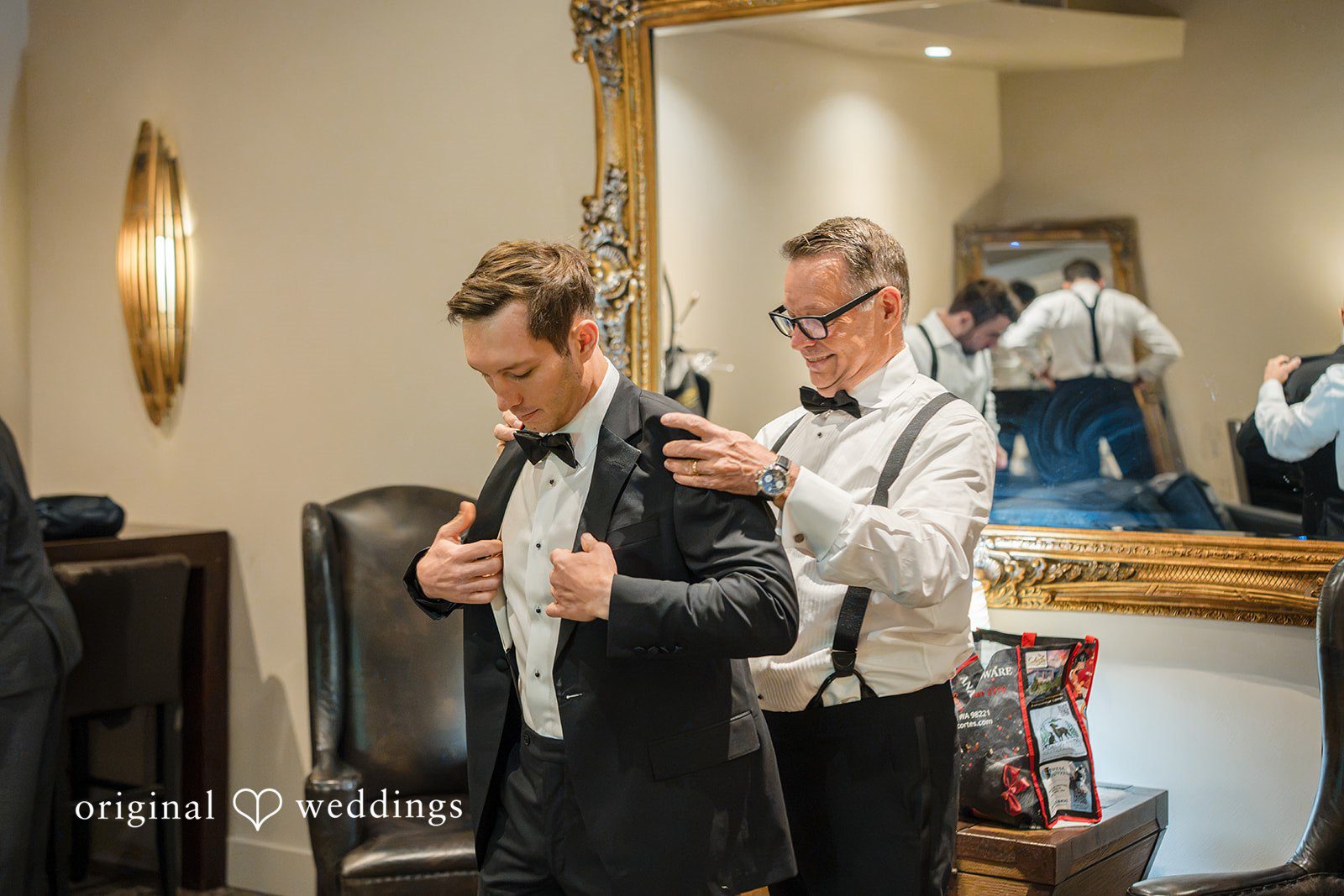 A groom getting adjusted by his groomsmen while preparing for the wedding ceremony.