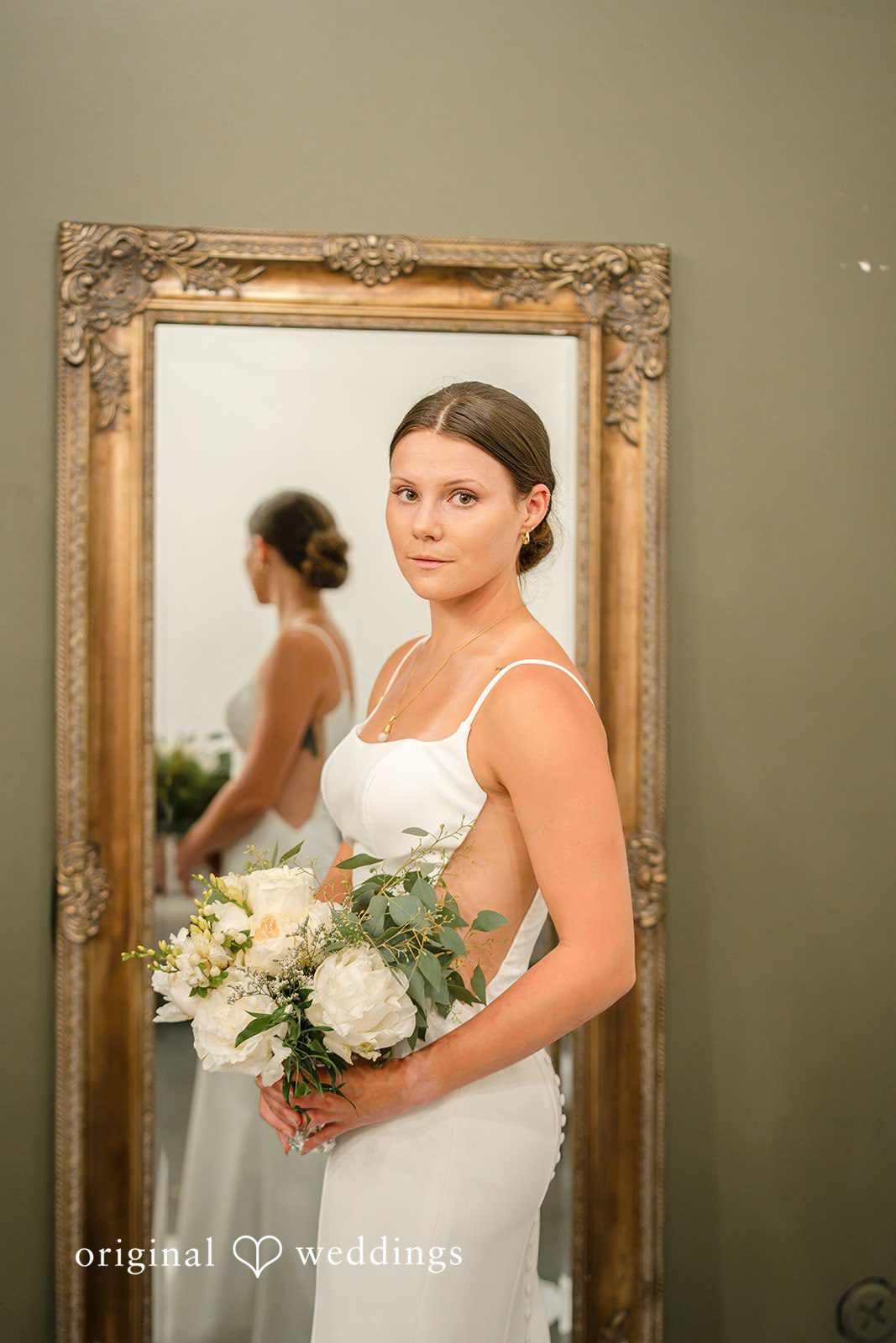A bride in her wedding dress holding a bouquet.