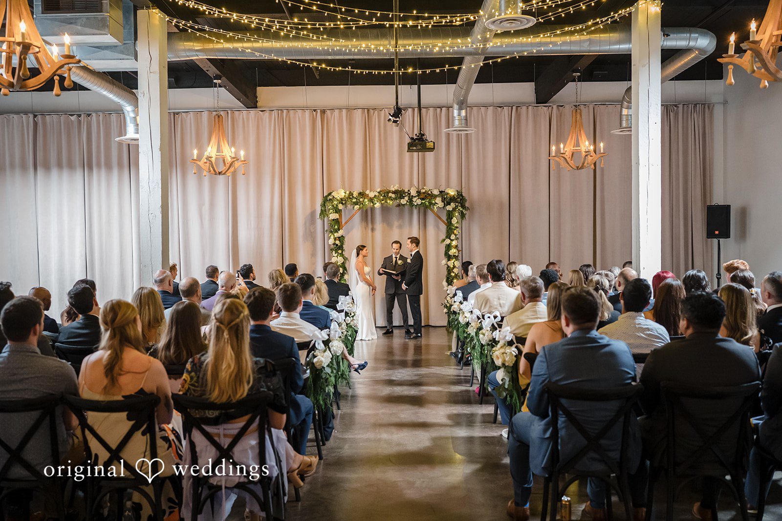 Wedding guests seated in rows facing the altar during a ceremony.