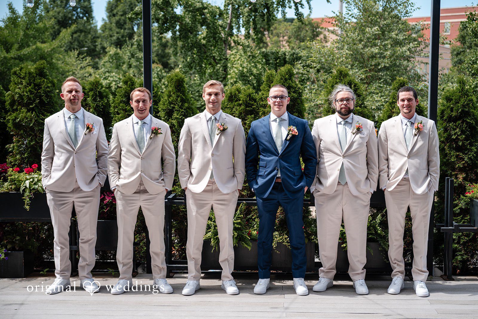 Lucy + Cormac Men in matching groomsmen suits standing side-by-side in a row.