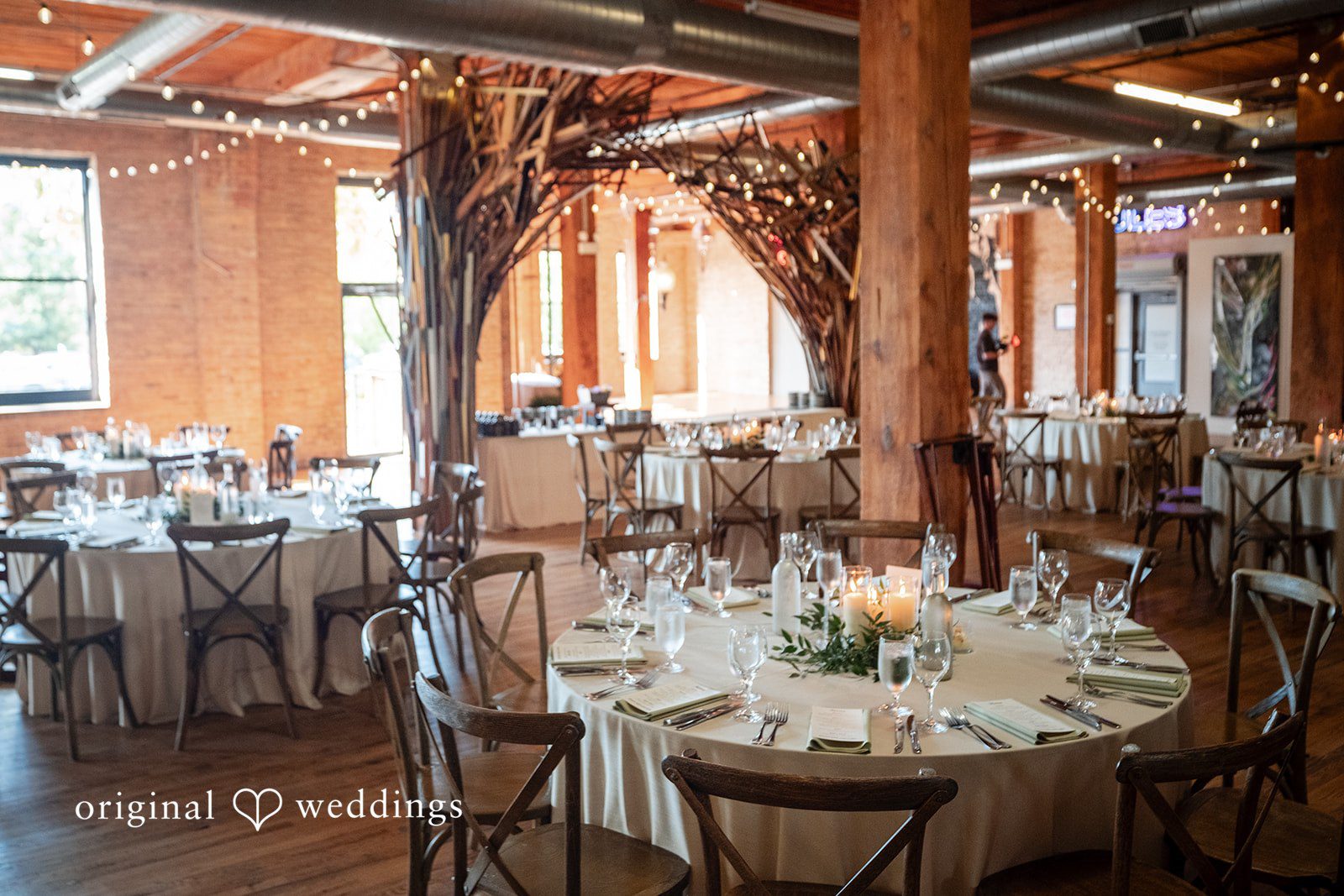 Lucy + Cormac A reception space filled with round dining tables set for a banquet.