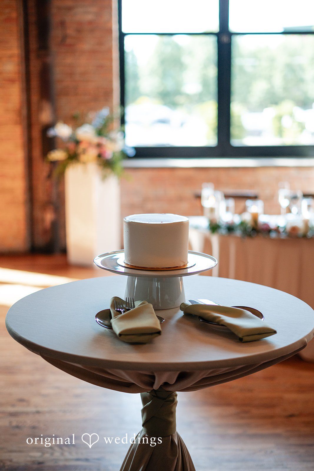 Lucy + Cormac A round wooden table adorned with candles and small decorations.