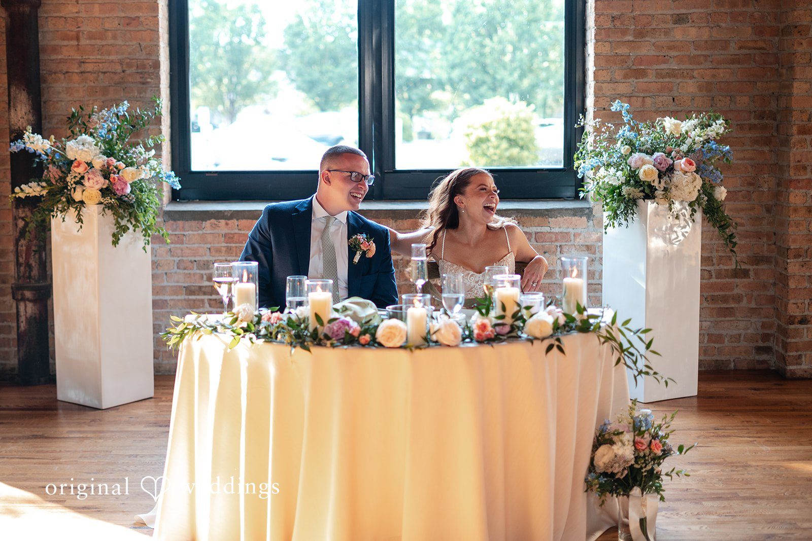 Lucy + Cormac A bride and groom sitting together behind a round banquet table.