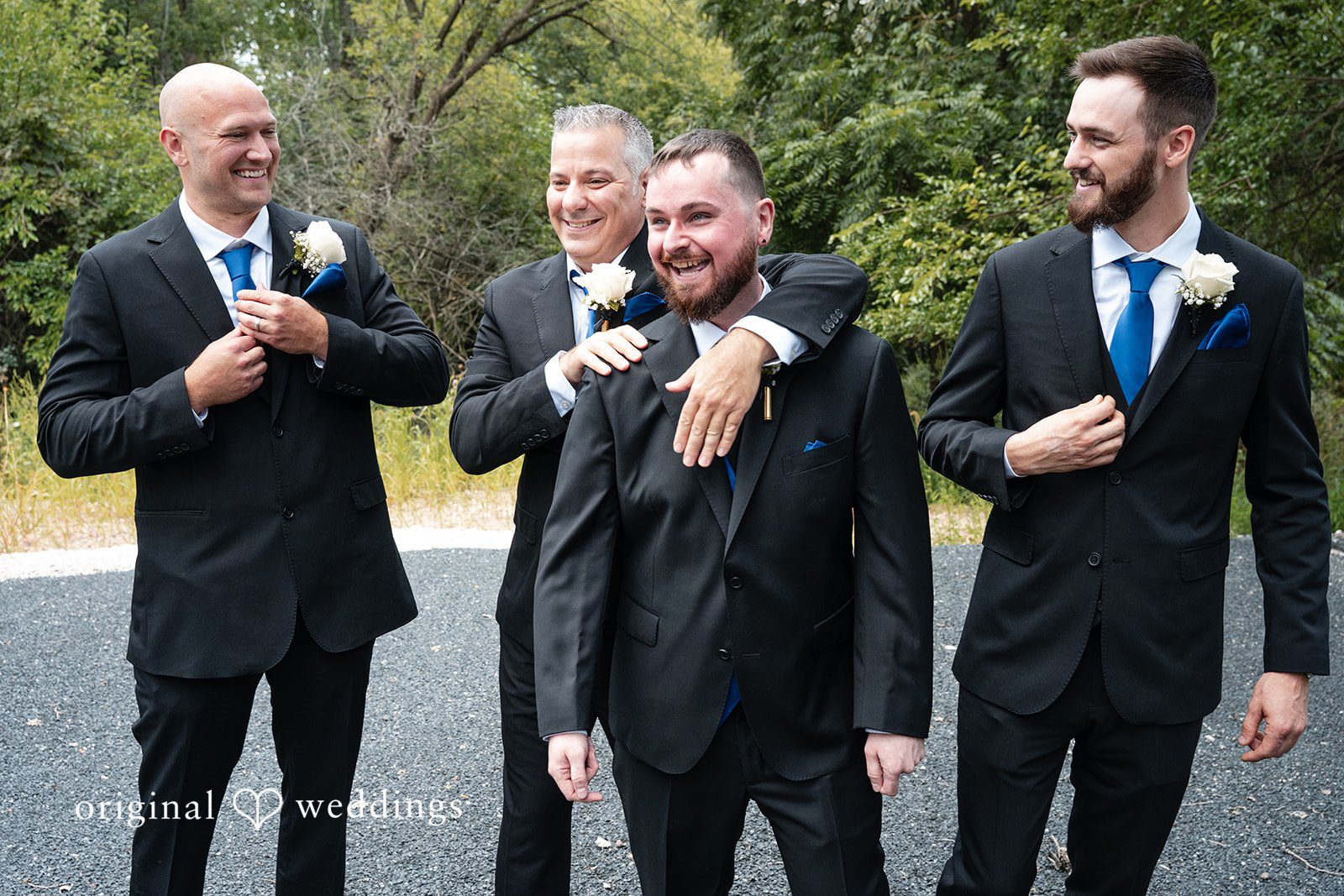 Groomsmen laughing and posing together in matching suits.