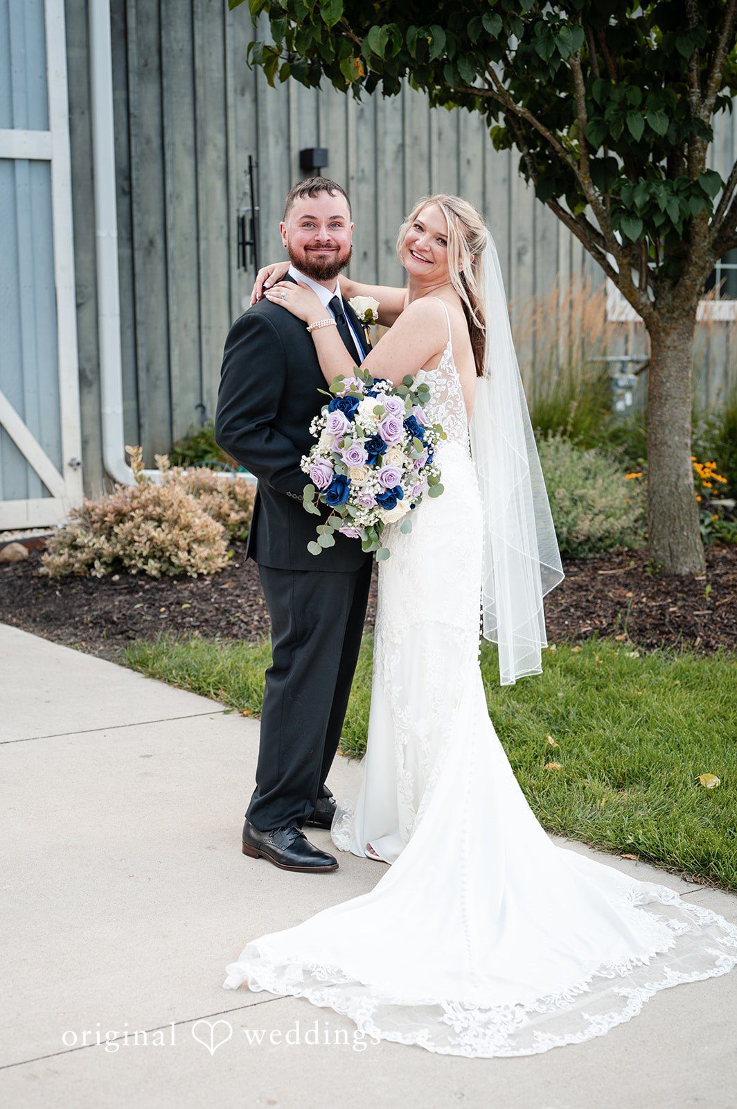 A groom and bride standing together at Lilac Acres.